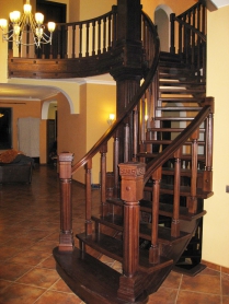 Винтовая лестница из дуба с гнутым косоуром и резными столбами. Покраска «Темный орех»