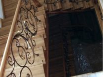Дубовая лестница с кованым ограждением, покрытая лаком